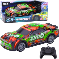 RC dirkalni avto s svetlečo karoserijo oranžno‑zelen