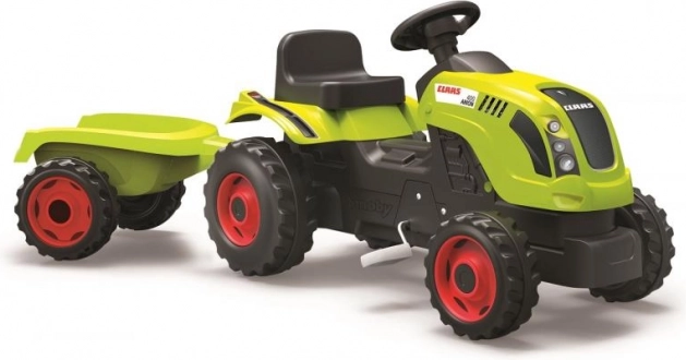 Poganjalni traktor CLAAS z zelenim prikolnikom