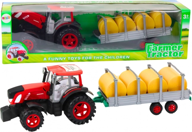 Velik traktor s prikolico in balami sena