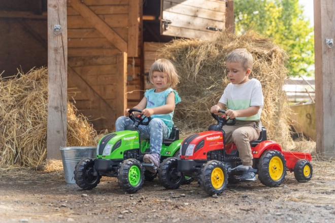 Pedalni traktor z rdečo prikolico