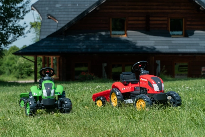 Pedalni traktor z rdečo prikolico