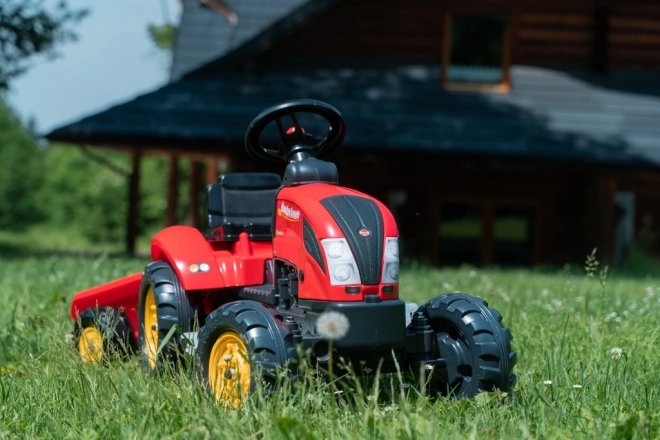 Pedalni traktor z rdečo prikolico