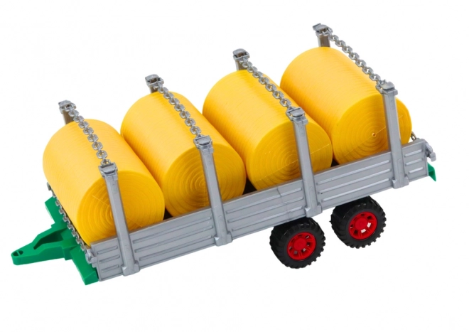 Velik traktor s prikolico in balami sena