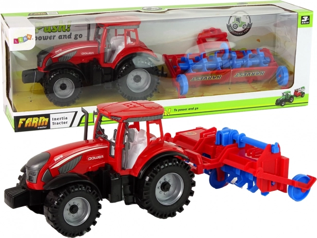 Rdeč traktor s plugom s trenjskim pogonom
