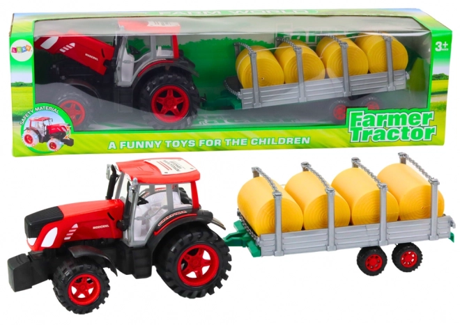 Velik traktor s prikolico in balami sena