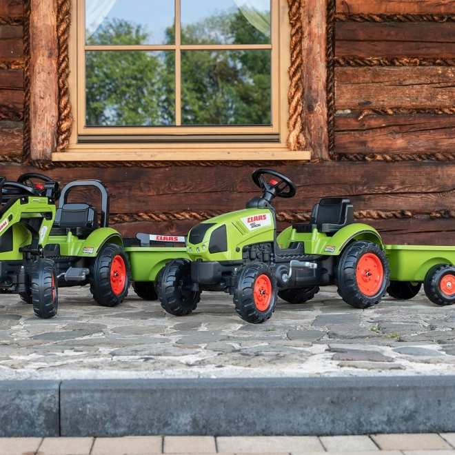 Šlapalni traktor Claas Arion 410 z zeleno prikolico