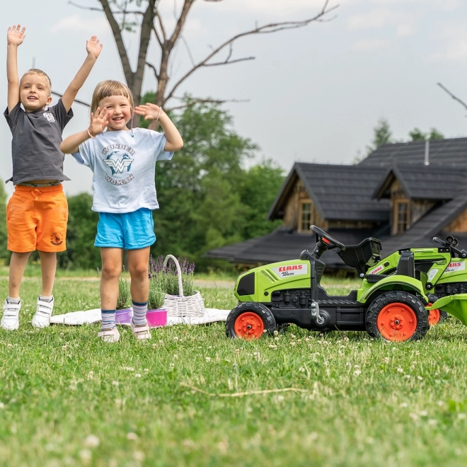 Šlapalni traktor Claas Arion 410 z zeleno prikolico