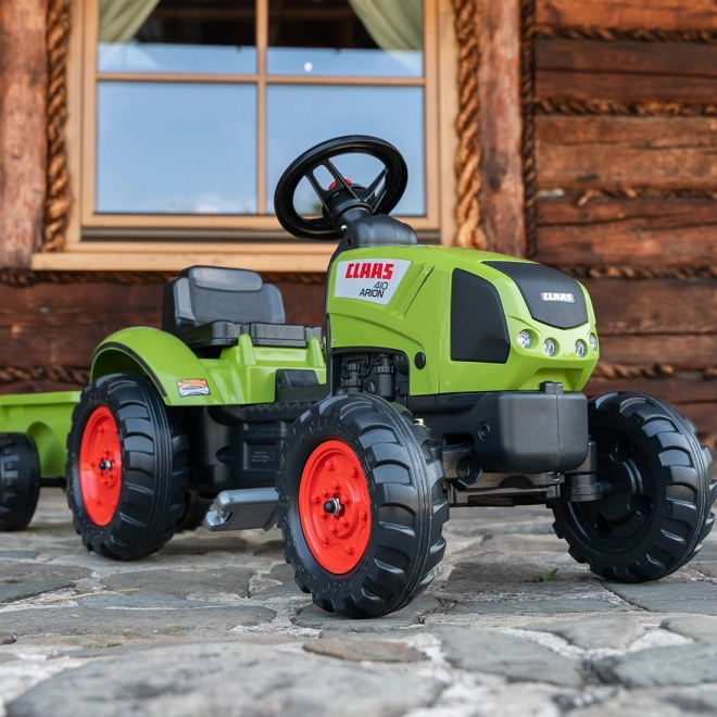 Šlapalni traktor Claas Arion 410 z zeleno prikolico