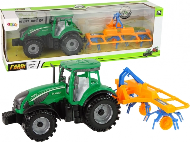 Zeleni traktor z grabljami s trenjskim pogonom